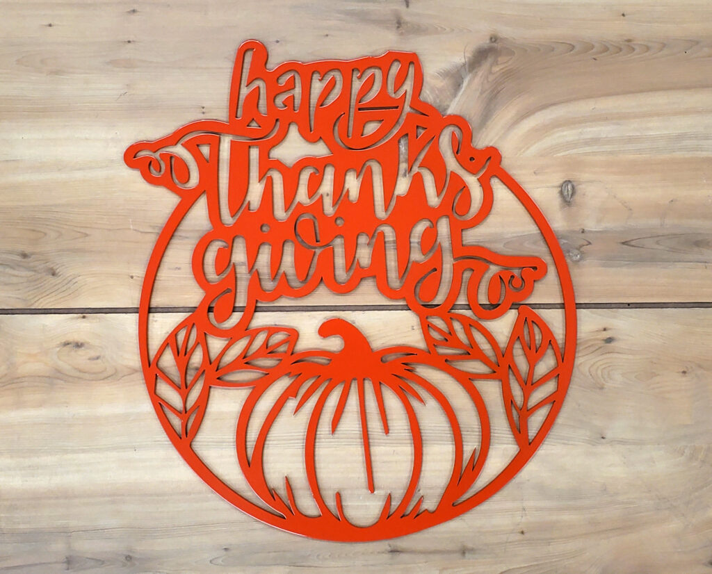 Orange metal wall decor that features fall theme and says "Happy Thanksgiving"